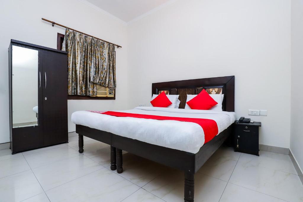 a bedroom with a large bed with red pillows at OYO Hotel Shiv Shakti Inn Near Kamal Cinema in New Delhi