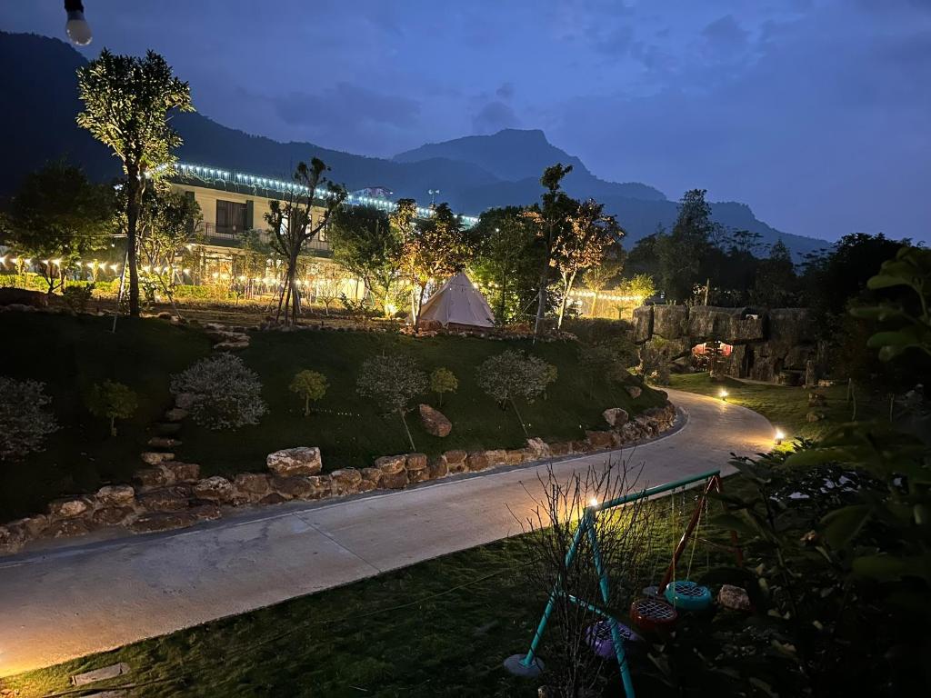 a view of a garden at night with a tent at King Bavi Resort in Xóm Cầu Rồng