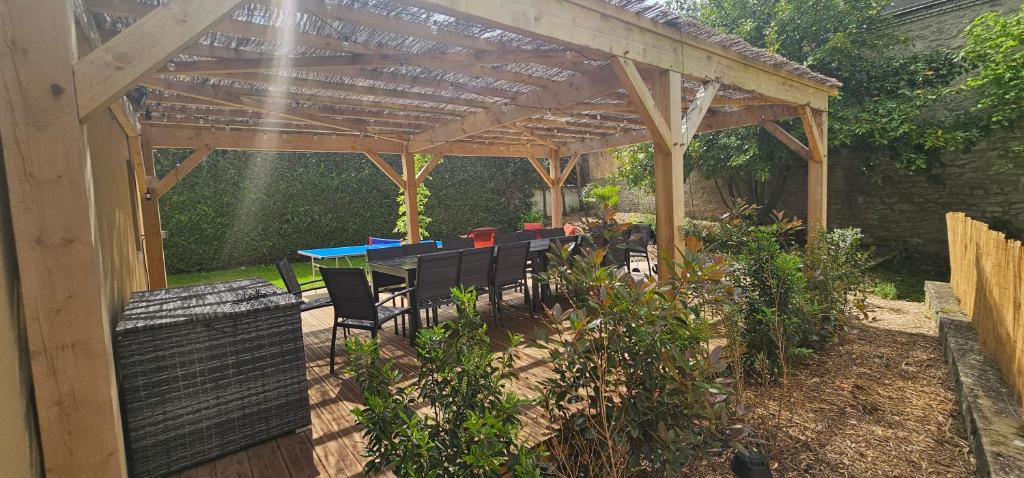 a wooden pergola with a table and chairs under it at Le Clos Maldier - Gîte de la Belle vue in Laon