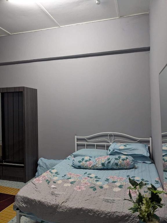 1 dormitorio con 1 cama con sábanas azules y flores en Homestay Koi en Temerloh