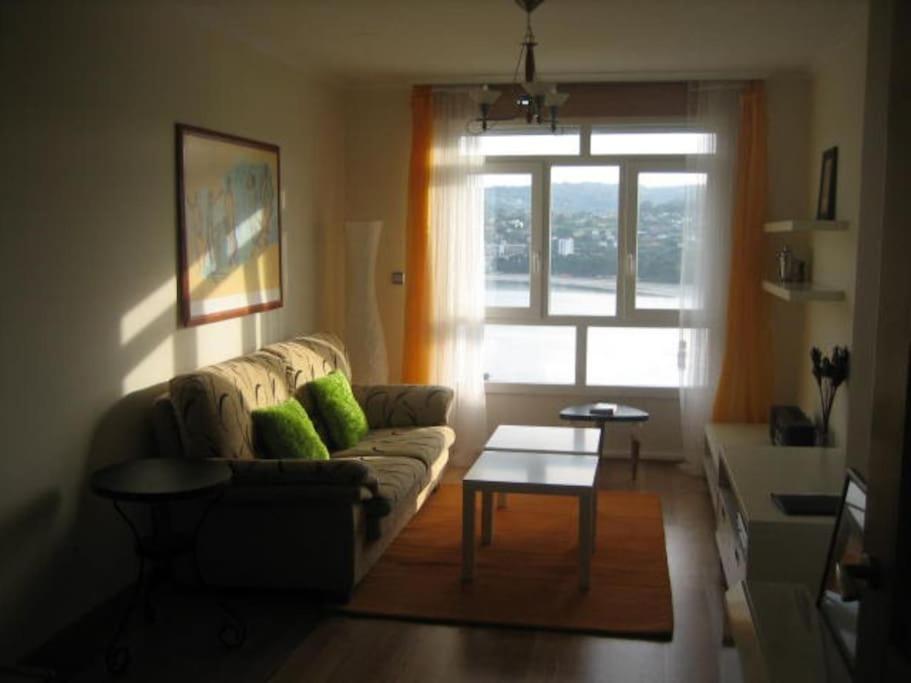 een woonkamer met een bank en een raam bij Precioso apartamento con excelentes vistas al mar in Puentedeume