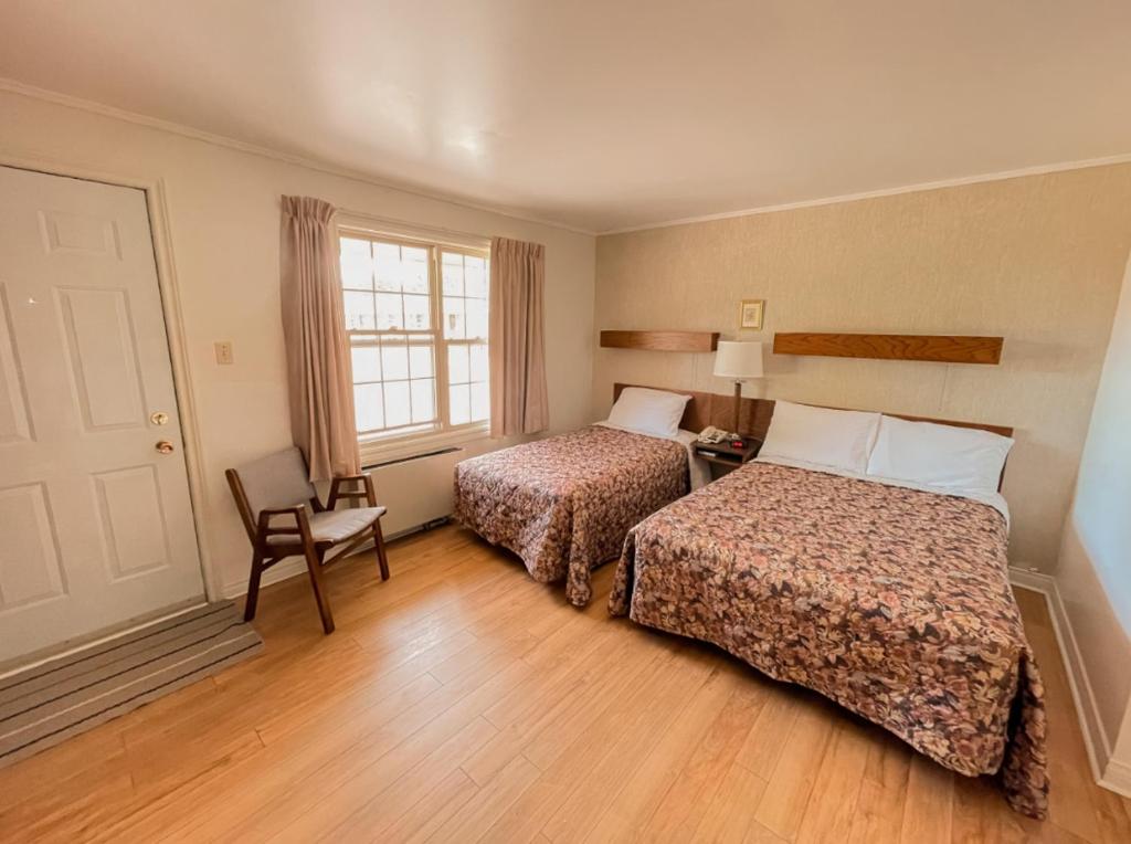 une chambre d'hôtel avec deux lits et une fenêtre dans l'établissement Silverwood Motel, à Cavendish
