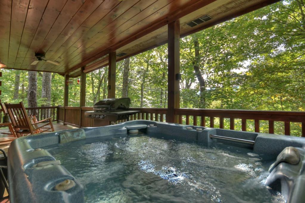 艾利傑的住宿－Bearfoot Ridge Wood-burning fireplace cozy hot tub serene views，小屋甲板上的热水浴池