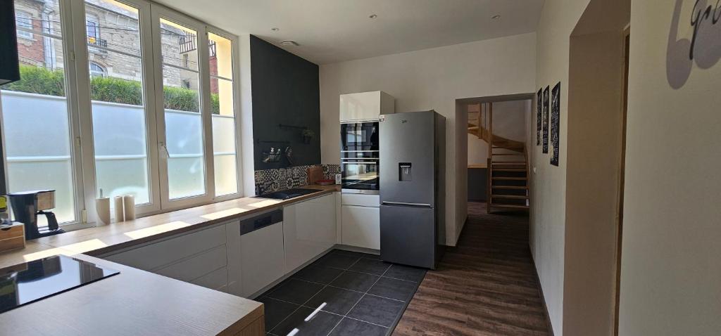 a kitchen with a stainless steel refrigerator in a room at Le Clos Maldier - Gîte de la Belle vue in Laon