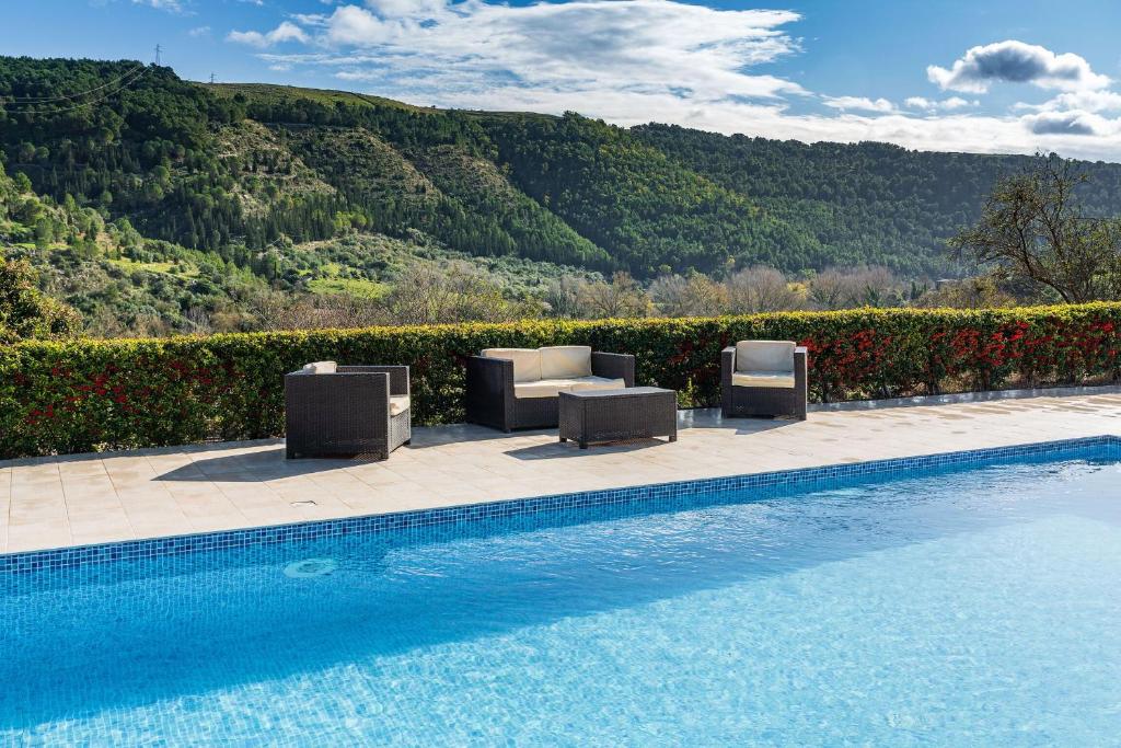 a swimming pool with lounge chairs and a pool at Casa Michela in Ragusa