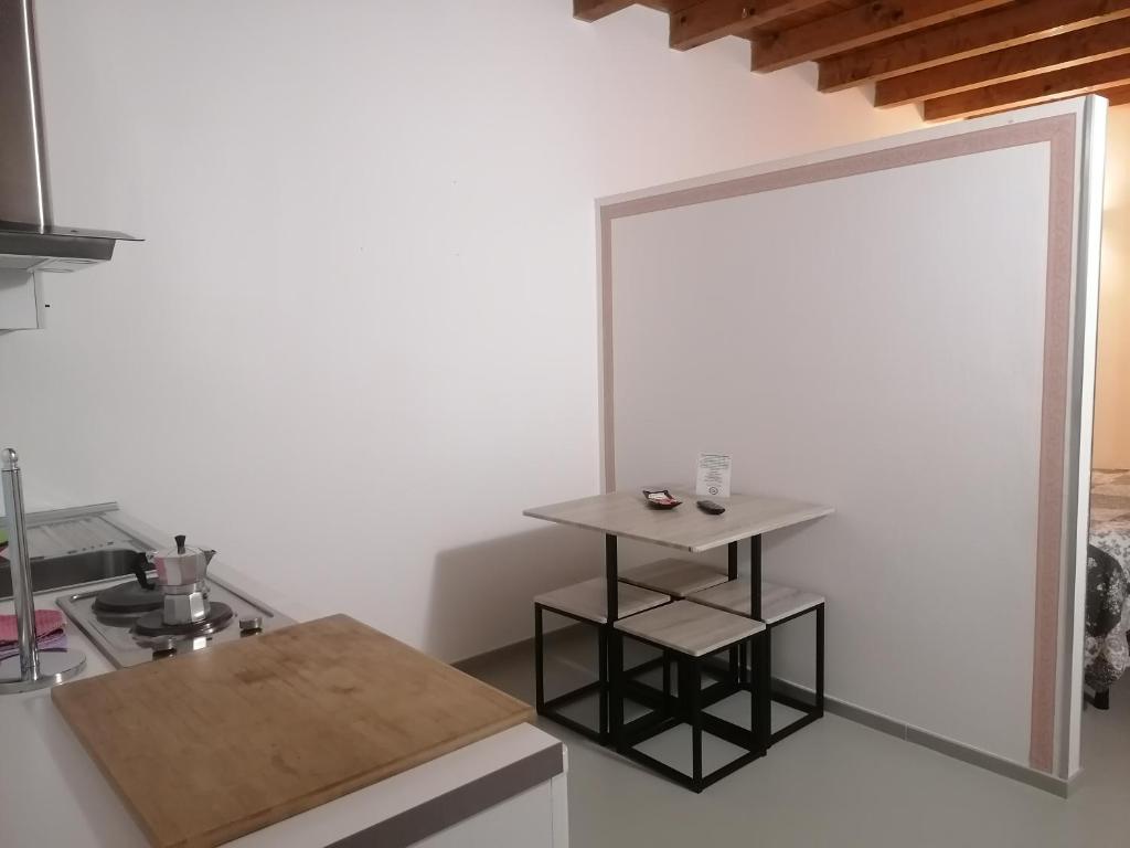 a kitchen with a small table and a mirror at A New Guesthouse in Pavia