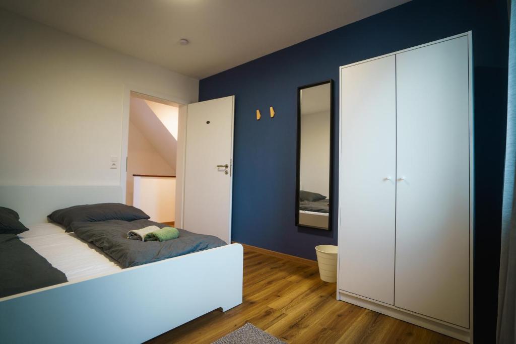 een slaapkamer met een bed en een blauwe muur bij Doppelzimmer 3 - neu renoviert in Dinkelsbühl