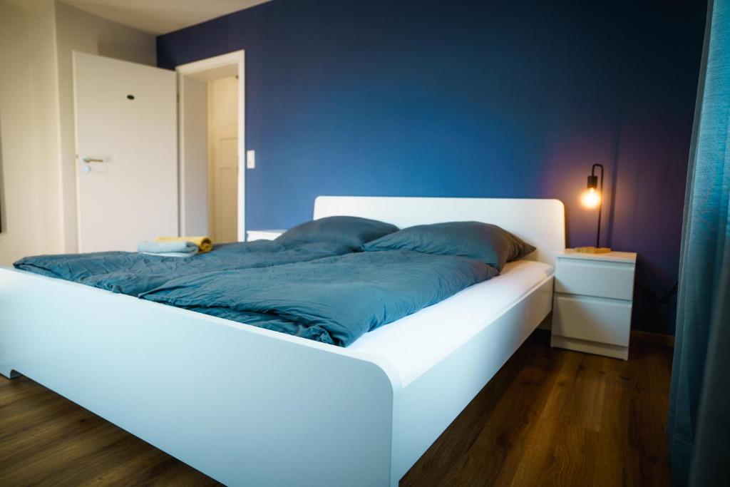 a white bed with blue pillows on it in a room at Doppelzimmer 2 - neu renoviert in Dinkelsbühl