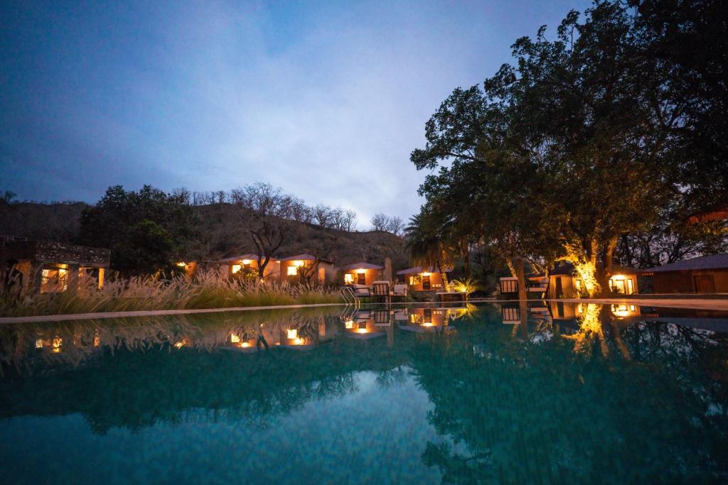 basen w nocy z oświetleniem w obiekcie Aloof Jungle Lodge w mieście Ghānerao