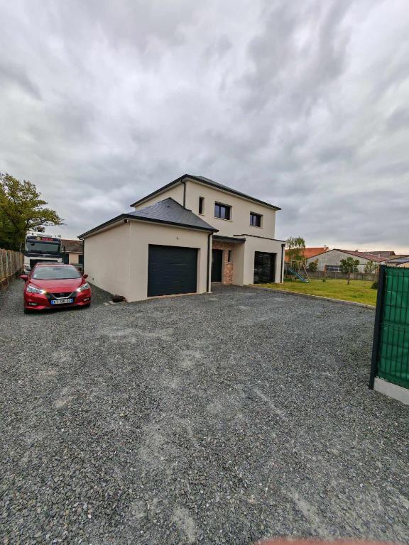 une voiture rouge garée devant une maison dans l'établissement Maison proche circuit Le Mans, à Mulsanne