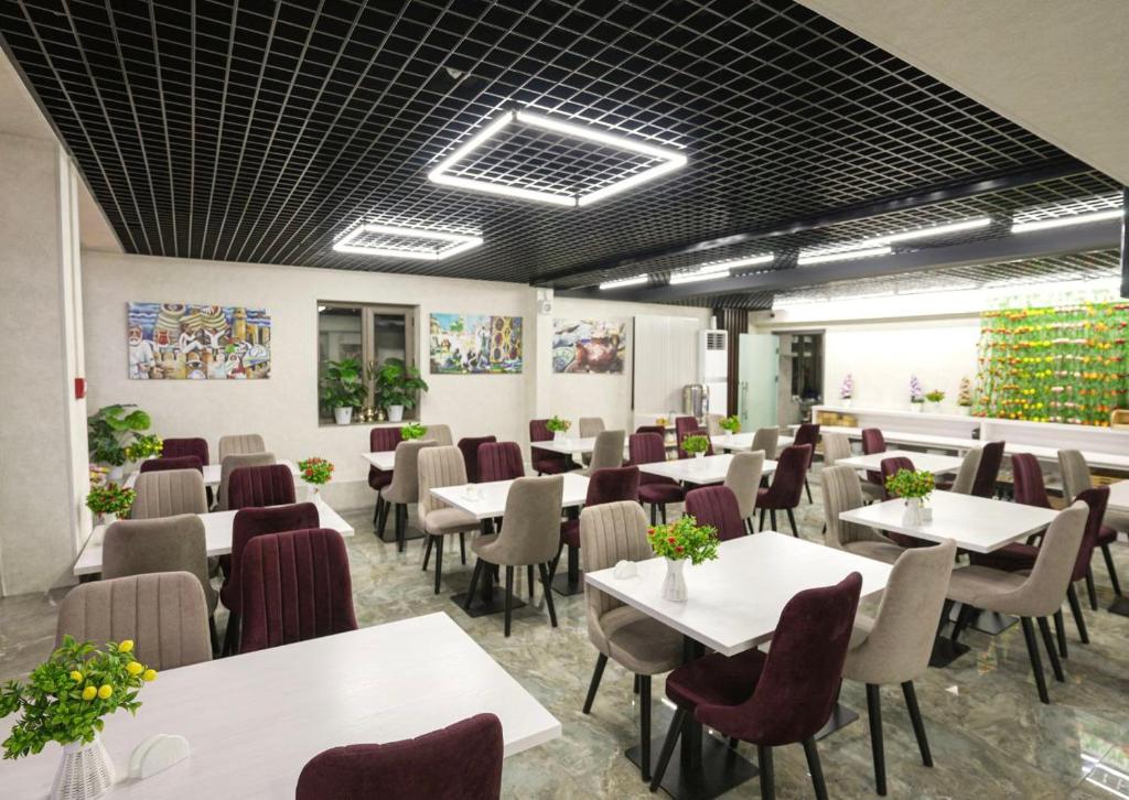 uma sala de jantar com mesas e cadeiras brancas em Moffah Grand Hotel 美华酒店 em Tashkent