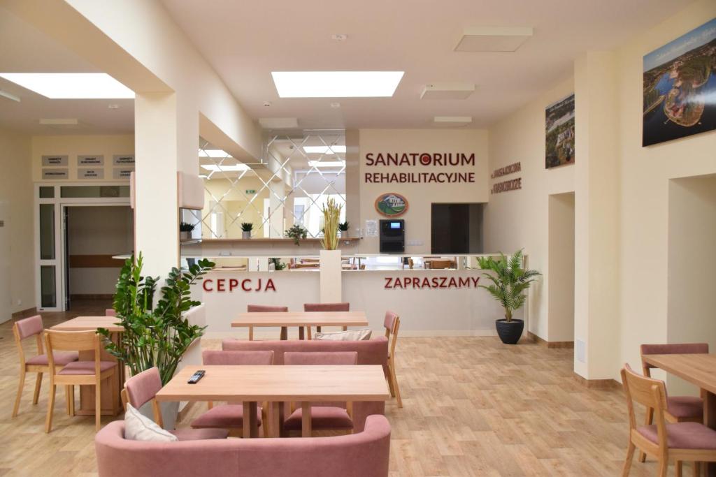 una caffetteria con tavoli e sedie in un edificio di Sanatorium Rehabilitacyjne im Janusza Korczaka a Krasnobród