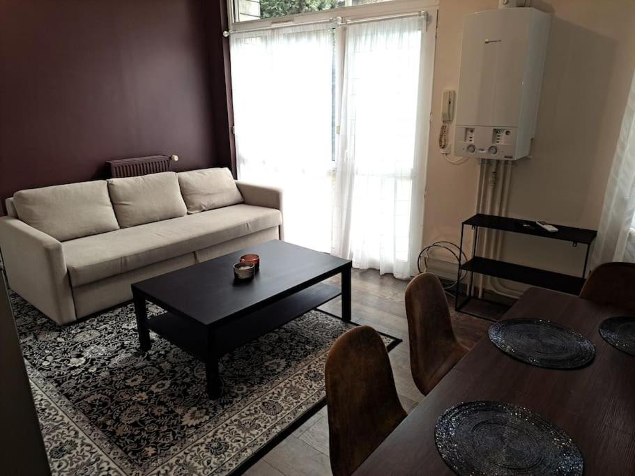 a living room with a couch and a table at Suite Chanzy 69 in Reims