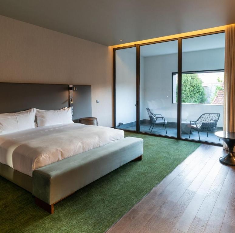 a bedroom with a large bed and a green rug at Great Gravity Hotel in Durban
