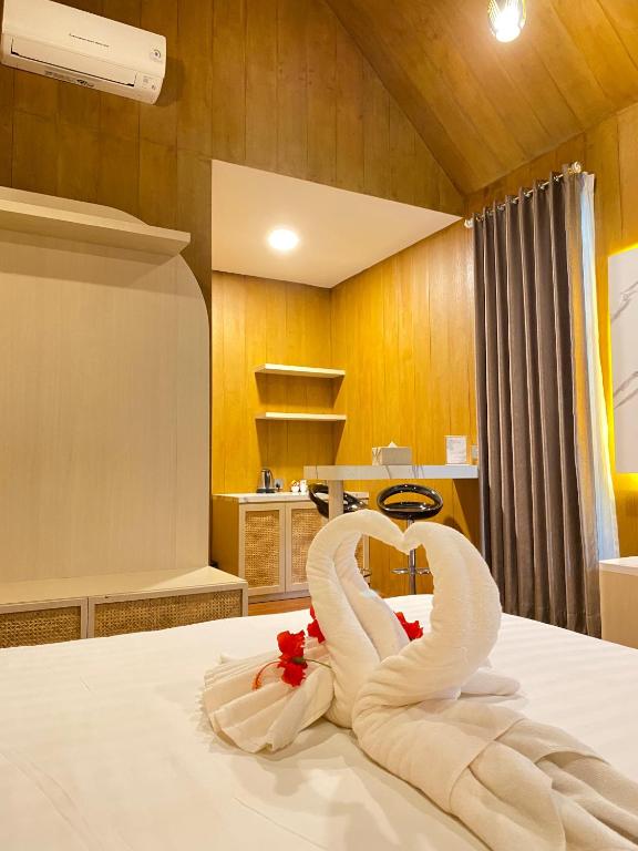 a bed with a swan made out of towels at Awandari Resort & Convention in Kangkakawal