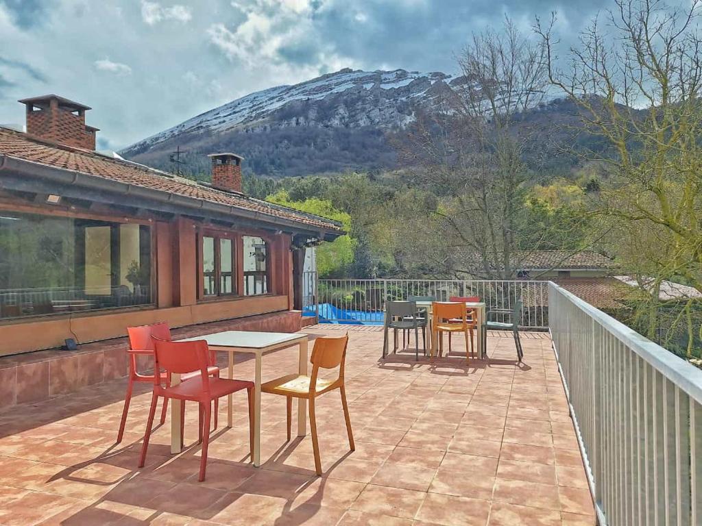 un patio con mesa, sillas y una montaña en Casa Rural Areano, en Escoriaza