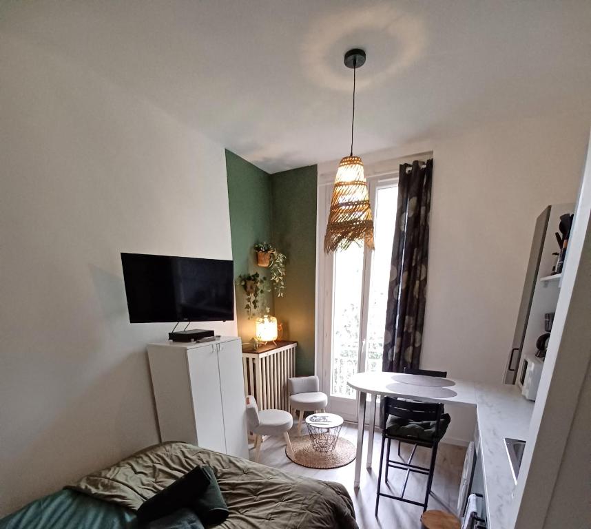 une chambre avec un lit, une table et une télévision dans l'établissement Studio M proche des thermes de Royat Chamalières à pieds, à Chamalières