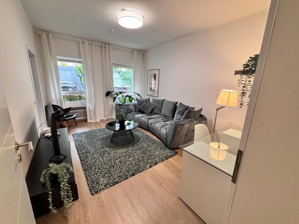 uma sala de estar com um sofá e uma mesa em RaumtoGo No1 Modernes Ruhiges 2-Schlafzimmer Apartment in Wiesbaden City & Park em Wiesbaden