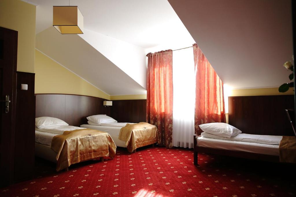 een hotelkamer met 2 bedden en een raam bij Hotel Kalchem in Brzozie