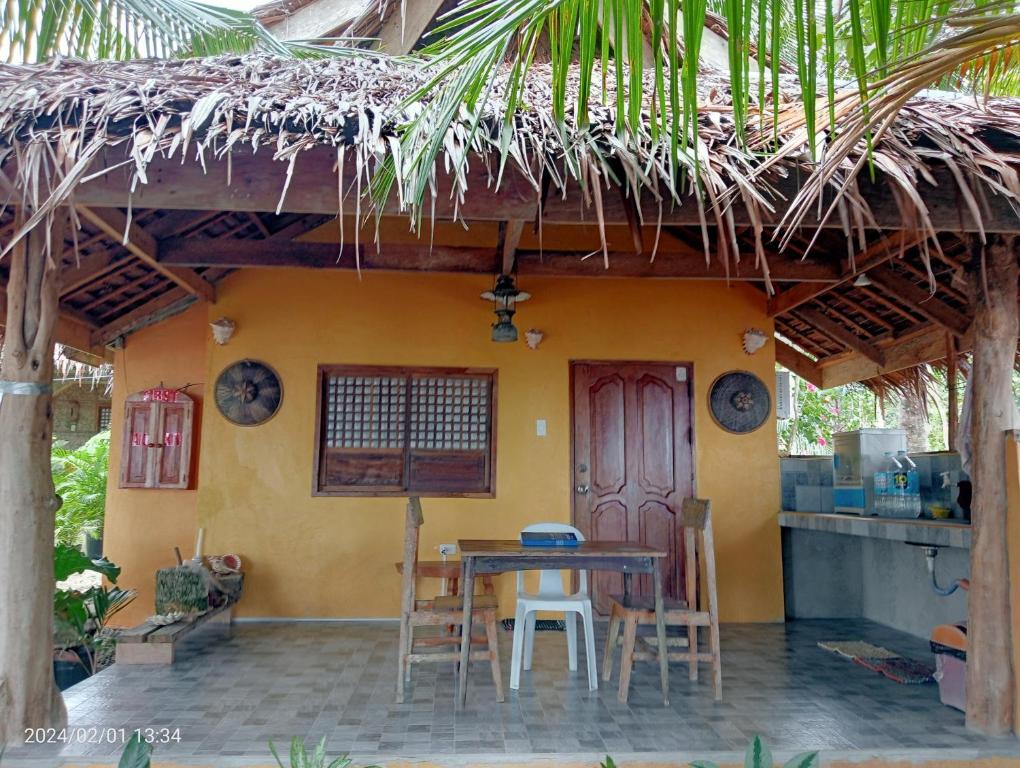uma mesa e cadeiras em frente a uma casa em Goldsky Seaview Budjong em San Juan