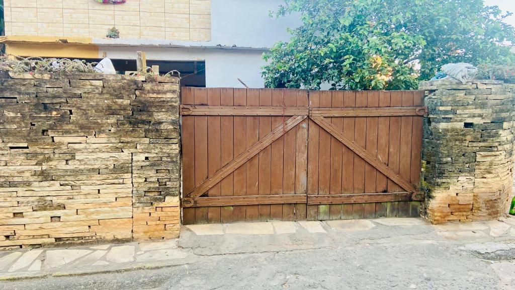Hostel Polansk في ساو ثومي داس ليتراس: سياج خشبي مع بوابة خشبية وجدار حجري