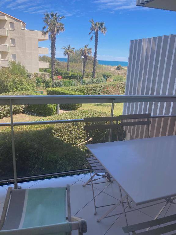 un balcon avec une table et une vue sur l'océan dans l'établissement SAIT CYPRIEN VUE MER résidence avec piscine, à Saint-Cyprien