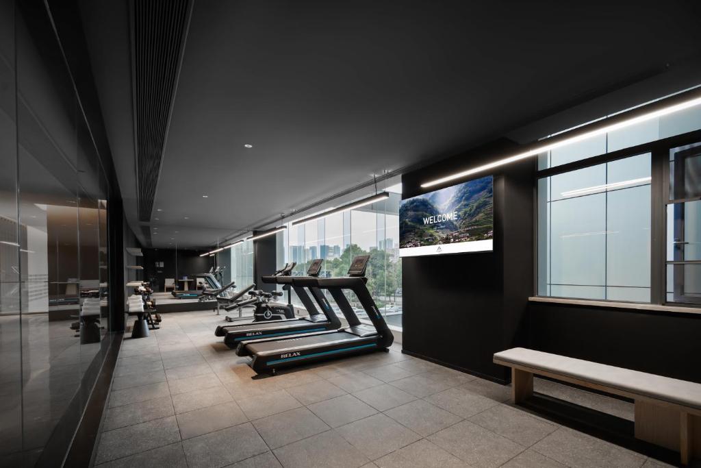 a gym with a row of treadmills and benches at Atour Hotel Chongqing Liangjiang Happiness Plaza in Chongqing