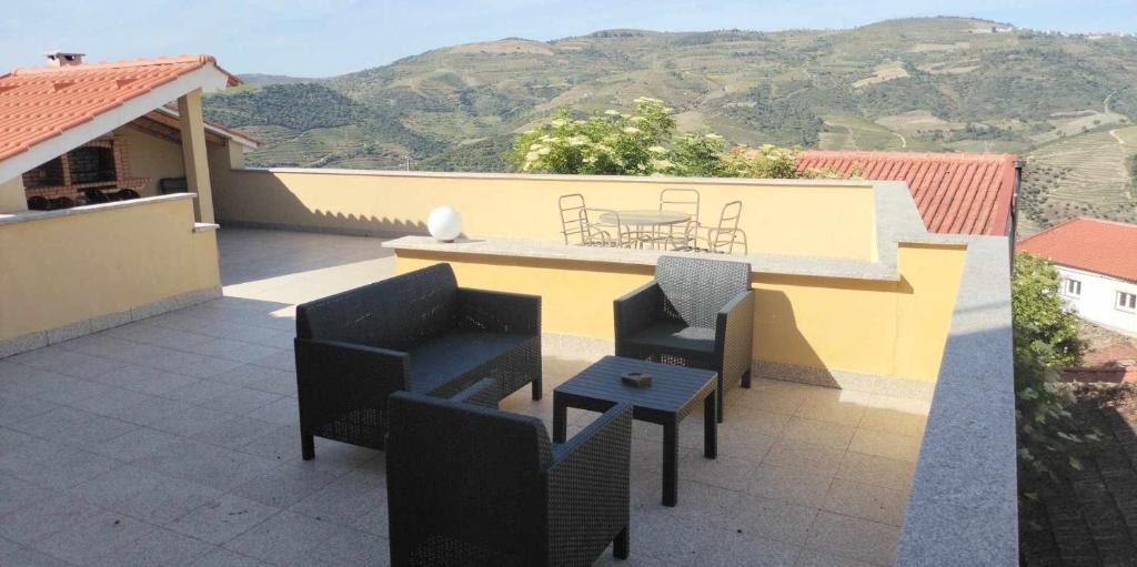 un patio con tavolo e sedie sul balcone. di Douro House a Tabuaço