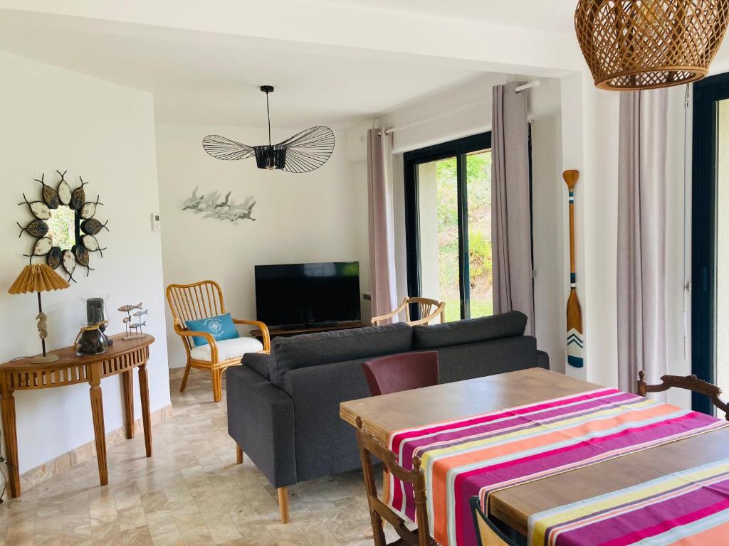 un salon avec un canapé et une table dans l'établissement La Bigorne, à Fouesnant