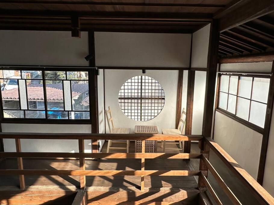 una camera con tavolo e alcune finestre di 昭和レトロが息づく狐白庵 a Nagano