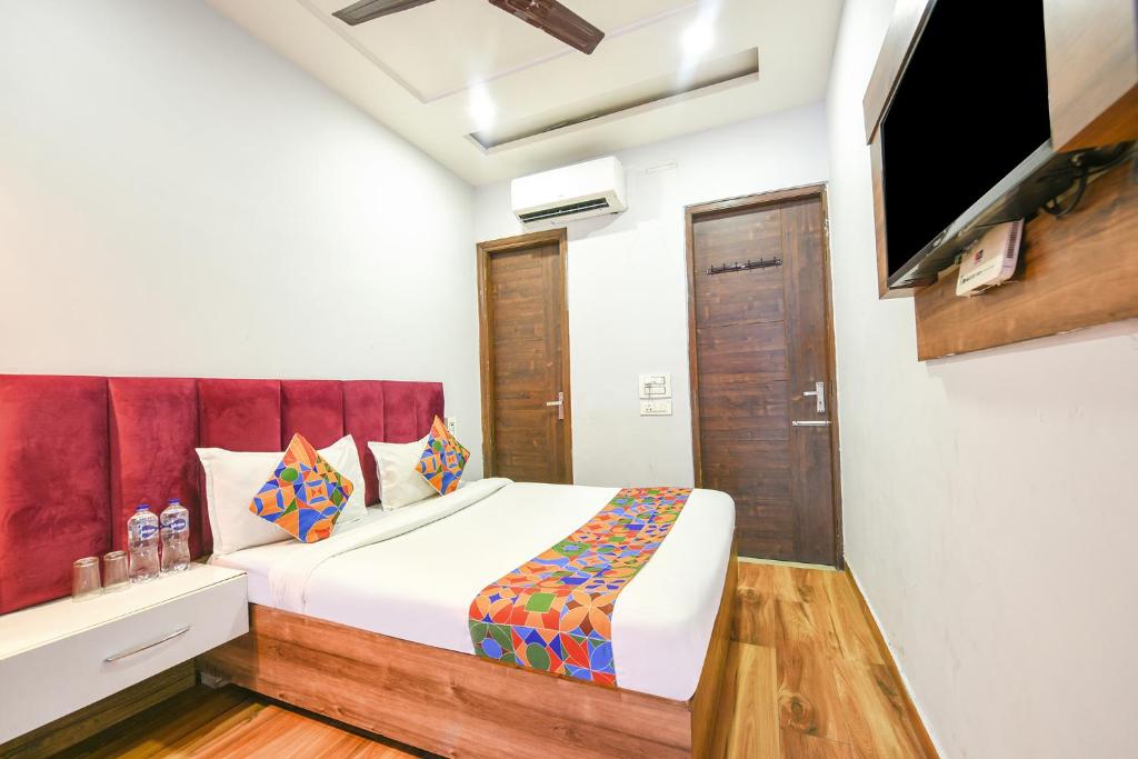 a bedroom with a bed and a flat screen tv at FabExpress 56 Amritsar in Amritsar