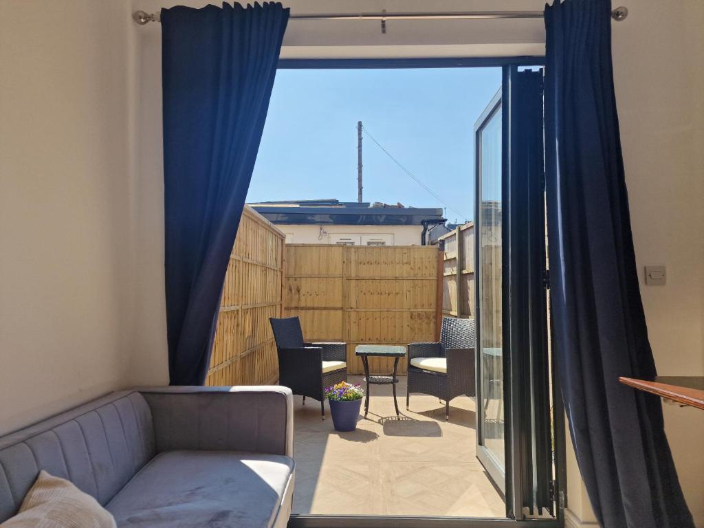 a living room with a couch and a window at Luxurious London Studios in Harrow