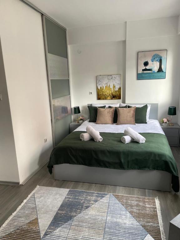 a bedroom with a large bed with two pillows on it at Kamche apartments in Skopje