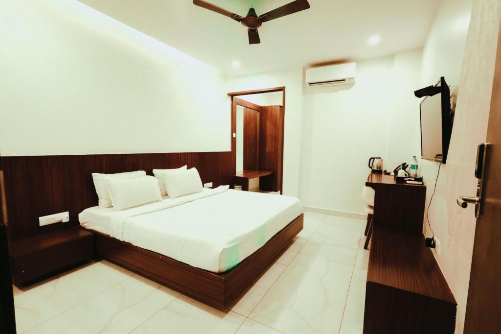 a bedroom with a bed and a television in it at Veerdency Luxury resort in Bangalore