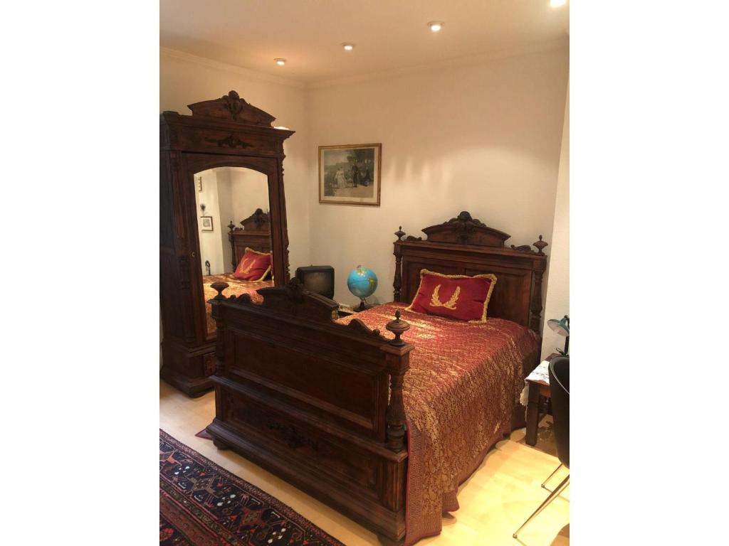 um quarto com uma cama de madeira e um espelho grande em Welcome! em Hanôver
