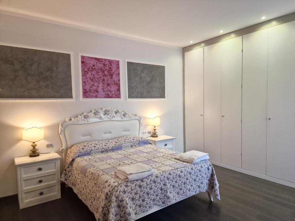 una camera con un letto con due comodini e due lampade di B&B Le Mura a Grosseto