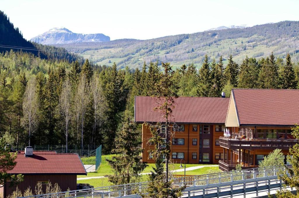 an image of a hotel with mountains in the background at Actif 106 - Hallingheim apartment ski inn/ski ut in Ål