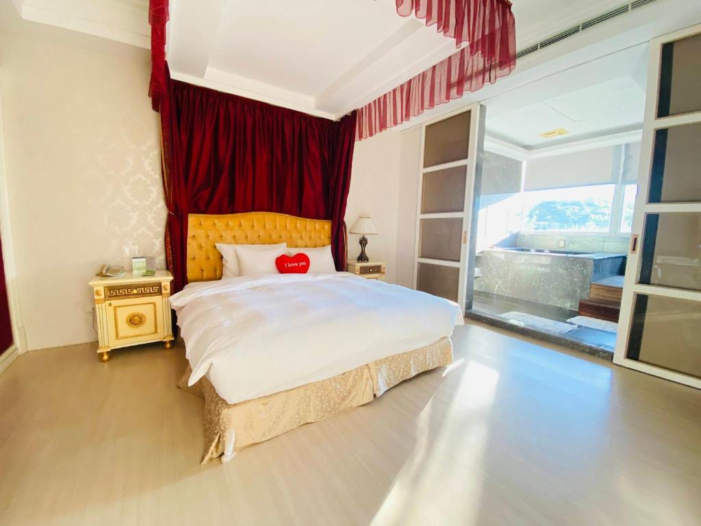 1 dormitorio con 1 cama grande y cortina roja en LIDO FORESTRY SPA RESORT en Yangmei