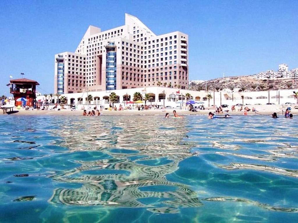 een groep mensen in het water op een strand bij Haifa Wonderful Flat for Wonderful People in Haifa