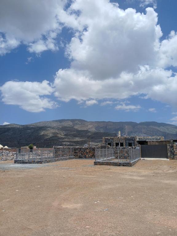 a building under construction with mountains in the background at Cloud housing jabal shams in Sa‘ab Banī Khamīs