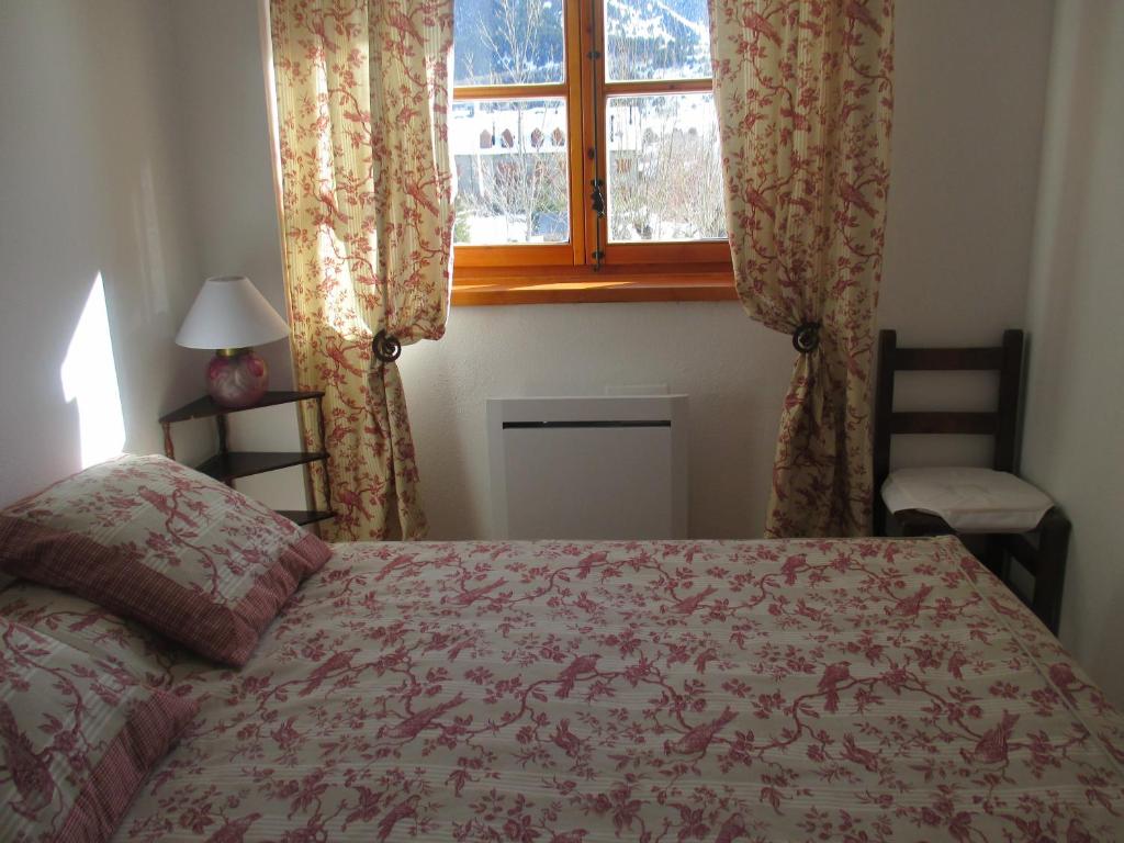 ein Schlafzimmer mit einem Bett und einem Fenster in der Unterkunft Appartement au Pla de l'Ermita dans la Vallée de BoÏ , Pyrénées Catalanes in Pla de l'Ermita