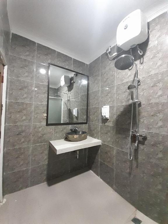 a bathroom with a sink and a mirror at Hotel Green Prundi in Labuan Bajo