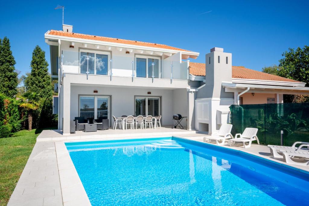 a villa with a swimming pool and a house at Isola di Albarella in Isola Albarella