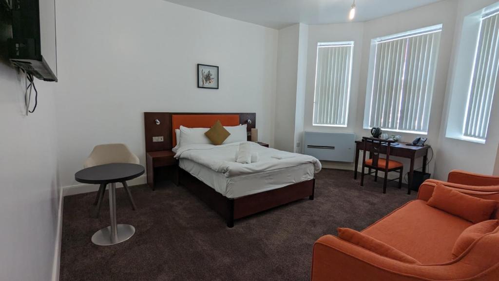 ein Schlafzimmer mit einem Bett, einem Tisch und einem Stuhl in der Unterkunft Hotel Blackpool in Blackpool