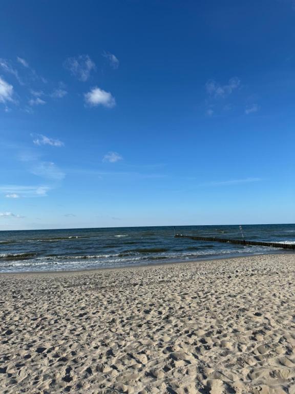 une plage de sable avec l'océan en arrière-plan dans l'établissement PORTA MARE KOŁOBRZEG Ul GEN MACZKA 29 3, à Kołobrzeg