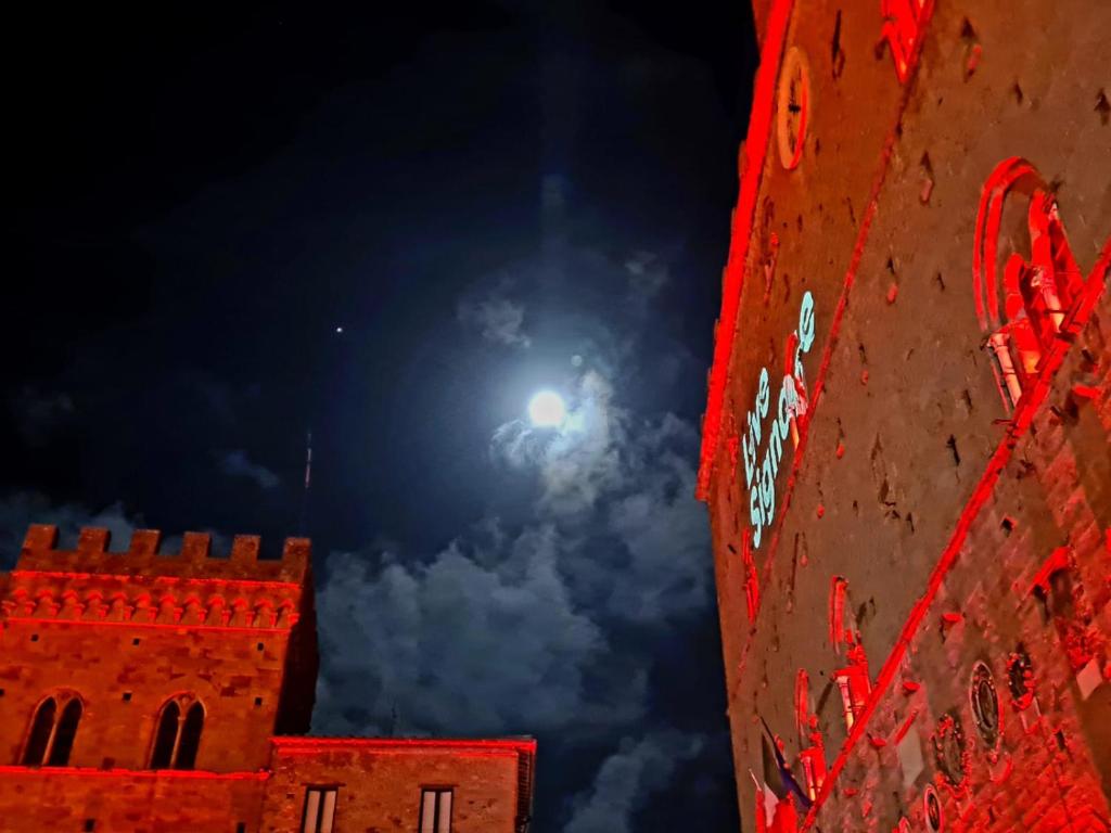 un edificio con la luna en el cielo detrás de él en CASA CENTRO STORICO VOLTERRA, en Volterra