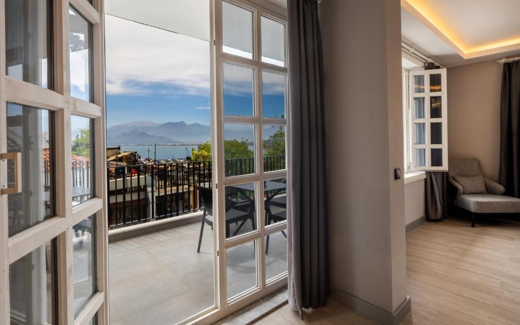 a room with a balcony with a view of the mountains at Royal Hayat Hotel Old Town in Antalya
