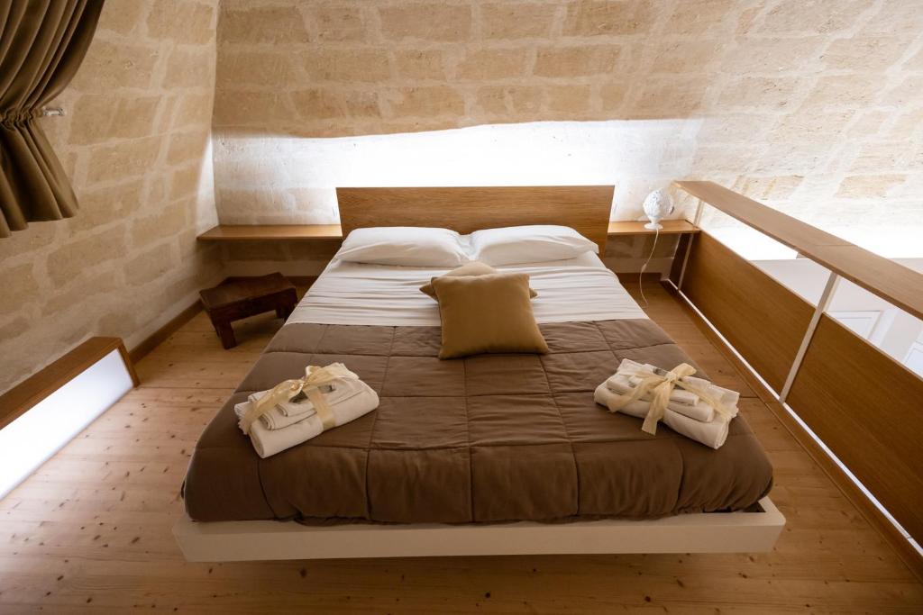 a bedroom with a large bed with towels on it at Antica Dimora Storica La Finestra Sul Campanile in Matera