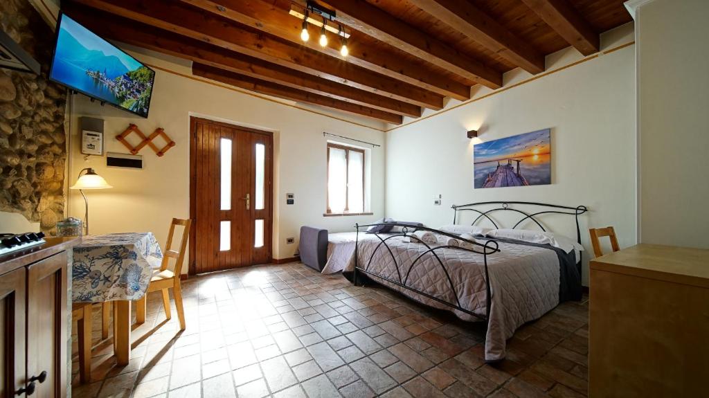 een slaapkamer met een bed en een tv in een kamer bij MeA on the Lake Cavalcaselle in Cavalcaselle