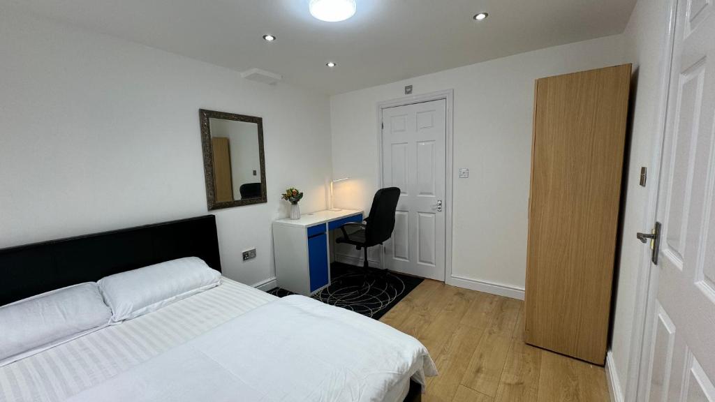 a bedroom with a bed and a desk and a mirror at Room with en-suite facilities in Ashford